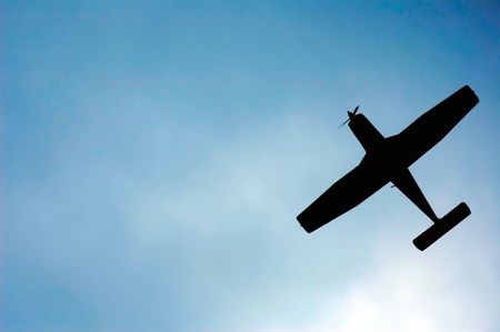light aircraft silhouette on cloudy skyの写真素材