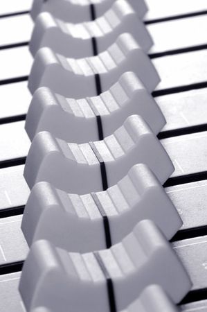 close-up line of soundboard mixer sliders