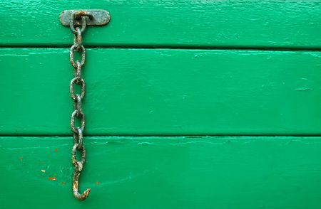 rusty hook and chain on green woodの写真素材
