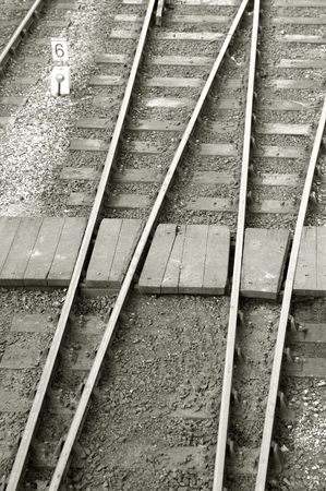 narrow pedestrian crossing across railroad tracks and pointsの写真素材
