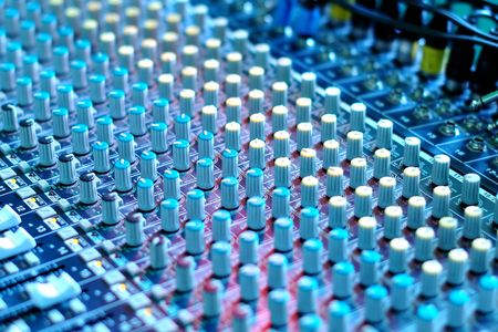 soundboard mixer under blue stage lighting
