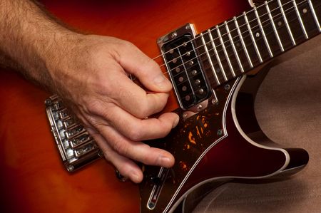 closeup of guitarists hand during a live performance