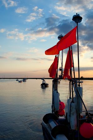 colorful sunset over the stern of a fishing boatの写真素材
