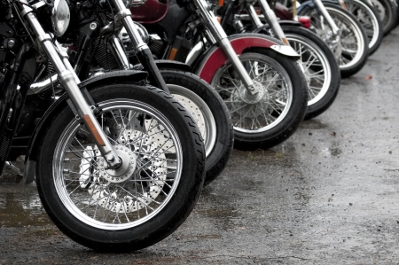 row of motorcycles parked together on a rainy dayの写真素材