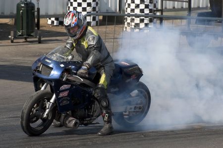 SANTA POD, UK - APRIL 23, 2010: Alternative energy racing at Santa Pod Raceway. A burnout by Andy Gilbert on his 150 mph biofuel powered Suzuki motorcycle. April 23, 2010, Santa Pod, UK.のeditorial素材