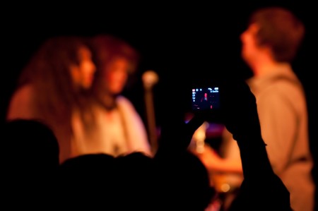 live band on stage being recorded by a mobile cell phoneの写真素材