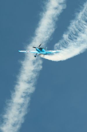 Farnborough International Airshow, UK - July 19, 2010: Blades aerobatic display pilot crossing the vapor trail of another aircraft. のeditorial素材