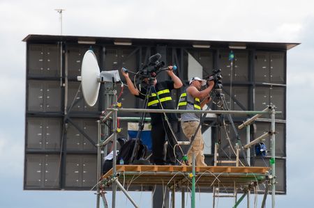 FARNBOROUGH AIRSHOW, UK - JULY 24, 2010: Event media cameramen shooting video footage directly to the giant screen behind them. のeditorial素材