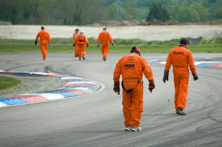 Thruxton, United Kingdom - May 1, 2011: Track safety marshalls inspect the circuit for debris between races at the Thruxton, British Touring Car Championship race meeting, UK.のeditorial素材