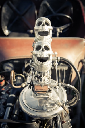 novelty skull carburetor air-intakes on top of a vehicle engine