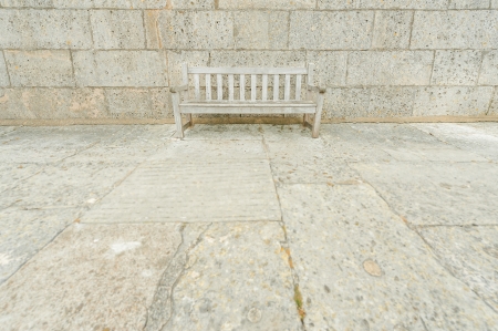 wooden park bench camouflaged by surrounding concrete blocksの写真素材