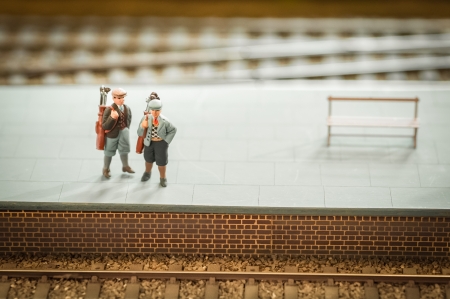miniature train set figures on a station platform with golf clubs