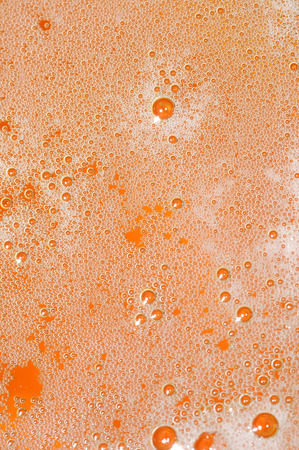 closeup of foam on top of a glass of beerの写真素材