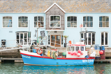 Weymouth Harbour UK   June 15  2013: Restaurant building and fishing boat on the picturesque quayside of Weymouth Harbour UKのeditorial素材