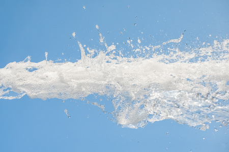 foaming water splash against a blue backgroundの写真素材