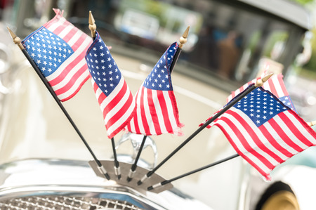 usa stars and stripes flags on the hood of a vintage automobile
