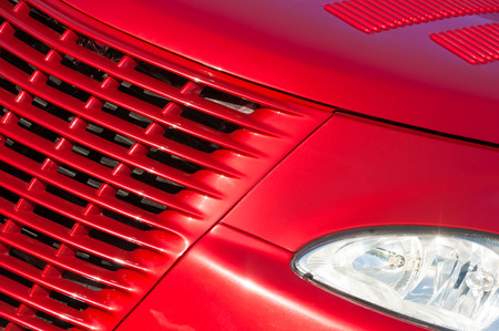 cherry red vehicle grille in bright sunlightの写真素材