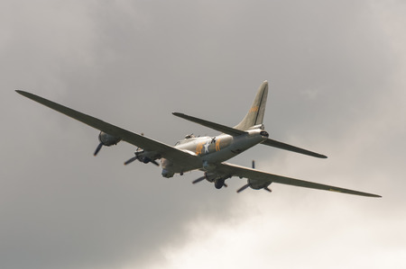 Farnborough, UK - July 17, 2016: Vintage Boeing B-17 Flying Fortress bomber in cloudy skies over Farnborough, UKのeditorial素材