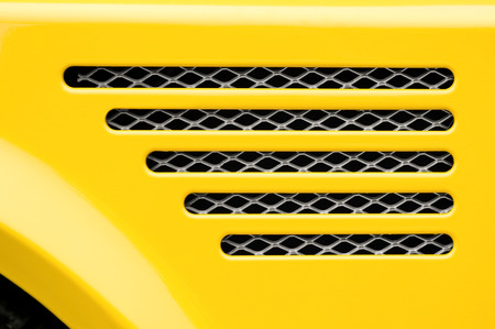auto engine grill closeup on a bright yellow vehicleの写真素材