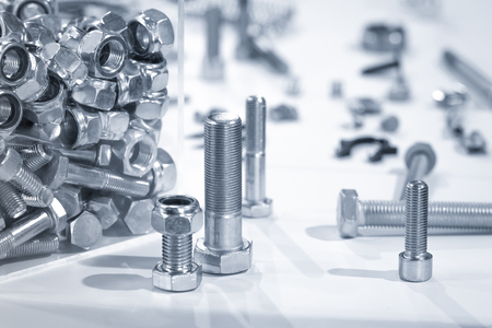 blue toned industrial nuts and bolts close-upの写真素材