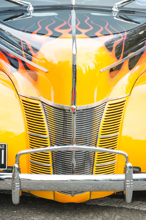 Hook, UK - January 1, 2019: Close-up of a chromed grille and vivid sunset yellow and flame paintwork...
