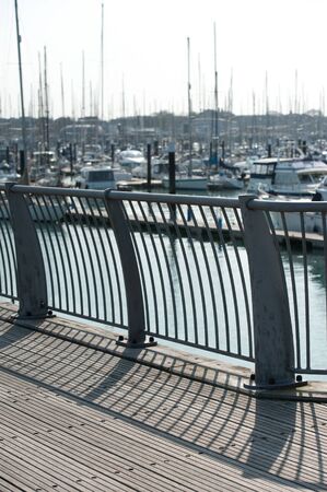 longs shadows falling around sailboat yachts in a marina