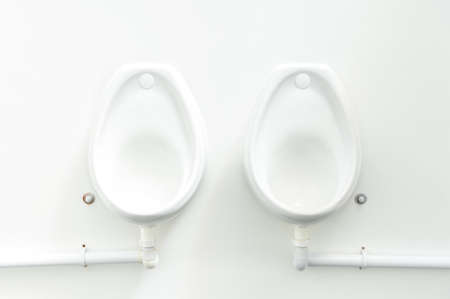 clean white public urinals fixed to a white wallの写真素材