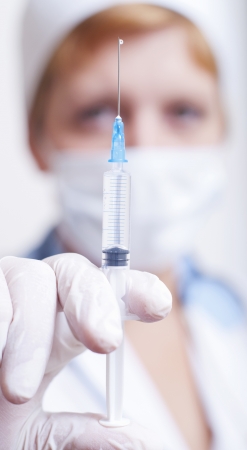 Close-up of a clinician holding syringe with medicineの写真素材