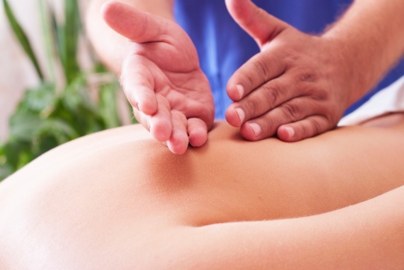 Close-up of a young woman receiving back massage at spaの写真素材