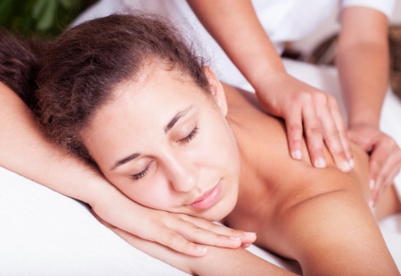 Close-up of a young woman receiving back massage at spaの写真素材