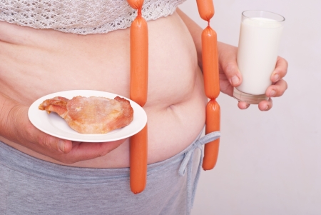 Fat woman holding meat and milkの写真素材