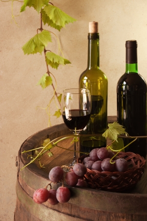 still life with red wine, bottle, glass and old barrelの写真素材