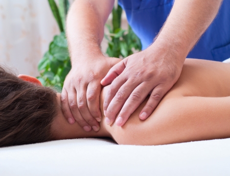Close-up of a young woman receiving back massage at spaの写真素材