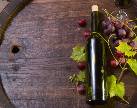 Background with red wine, bottle, glass and old barrel