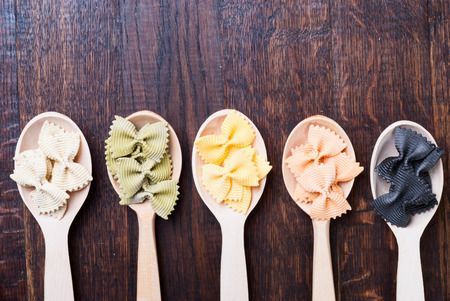Colorful pasta in wooden spoonsの写真素材