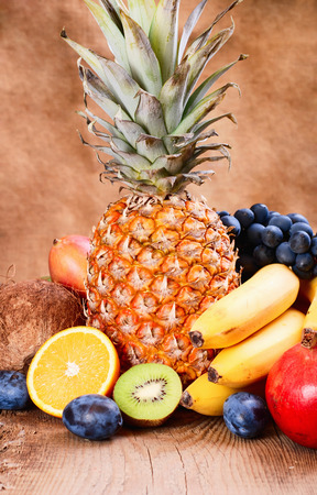 Many fresh colorful fruits on wooden backroundの写真素材