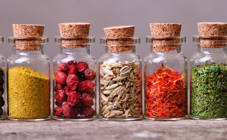 Spices in bottles on wooden backgroundの写真素材
