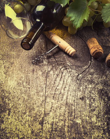 Bottle of white wine, grape and corks on old wooden backgroundの写真素材
