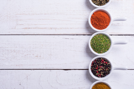 Spices and herbs in ceramic bowls on wooden background . Traditional Indian food .の写真素材