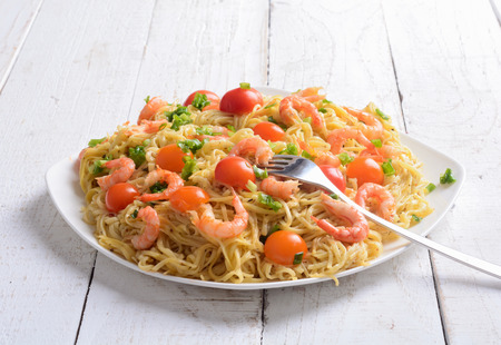 Pasta with shrimps & tomato on wooden backgroundの写真素材