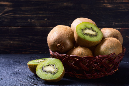 Still life with kiwi in basket on stone backgroundの写真素材