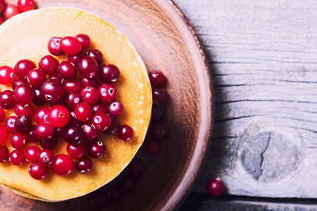 A stack of pancakes with cranberries on wooden backgroundの写真素材