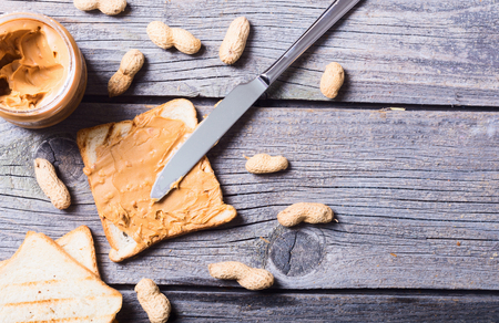 Peanut butter sandwiches or toasts on wooden background