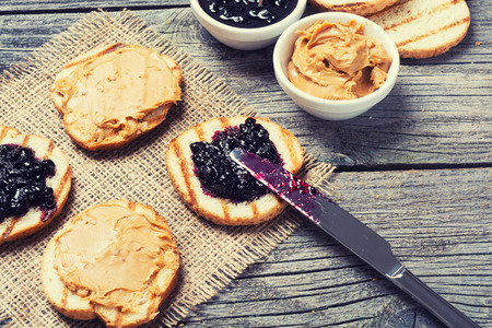 Peanut butter and jam sandwich on rustic wooden backgroundの写真素材