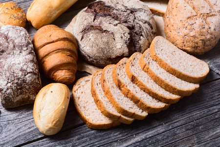 Fresh fragrant bread on wooden background . Food conceptの写真素材