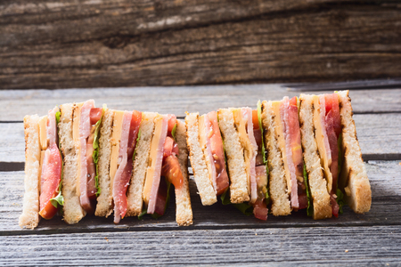 Club sandwich with bacon, tomato, cucumber and herbsの写真素材