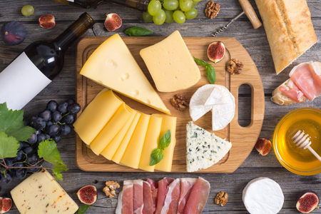 Different kind of cheese with wine, figs, walnuts, jamonの写真素材