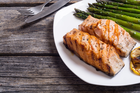 Fillet of grilled salmon with asparagus and lemonの写真素材