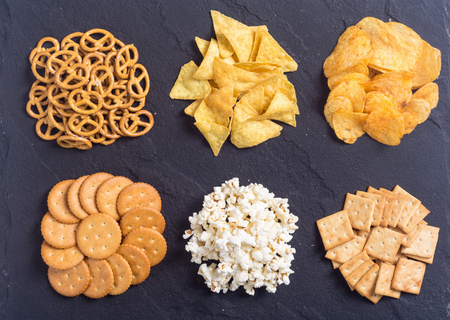 Frame . Mix of snacks : pretzels , crackers , chips , pop corn and nachosの写真素材