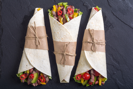 Burrito with beef , salad , tomato,  peppers and haricot . Food backgroundの写真素材
